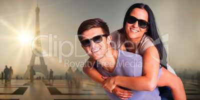 Composite image of man giving his pretty girlfriend a piggy back