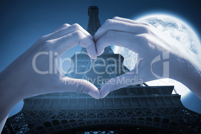 Composite image of hands making heart shape on the beach