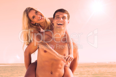 Laughing man giving his pretty girlfriend a piggy back smiling