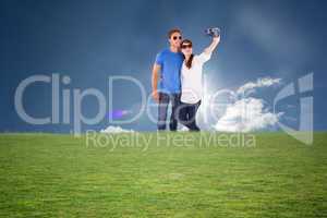 Composite image of couple using camera for picture