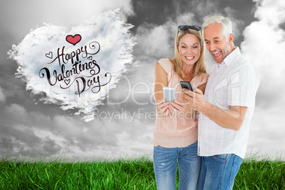 Composite image of happy couple looking at their smartphones