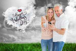 Composite image of happy couple looking at their smartphones