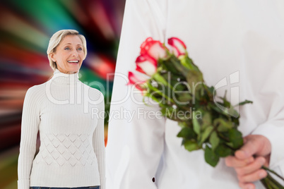 Composite image of man hiding bouquet of roses from older woman