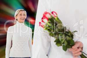 Composite image of man hiding bouquet of roses from older woman
