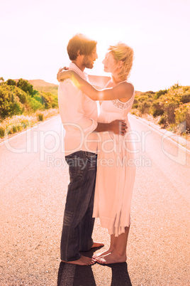 Attractive couple embracing barefoot on the road