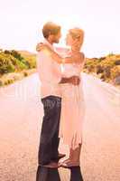 Attractive couple embracing barefoot on the road