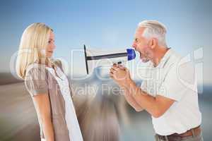 Composite image of angry man shouting at girlfriend through mega