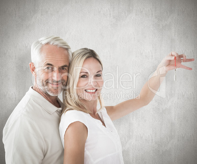 Composite image of happy couple showing their new house key