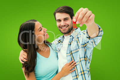 Composite image of happy young couple showing new house key