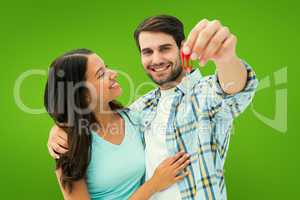 Composite image of happy young couple showing new house key