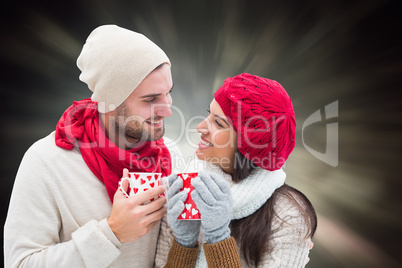 Composite image of winter couple holding mugs