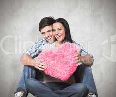 Composite image of young couple sitting on floor smiling