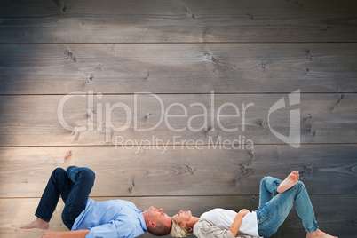 Composite image of mature couple lying and smiling