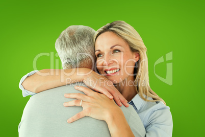 Composite image of happy couple standing and hugging