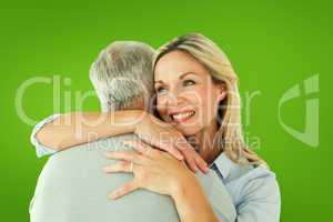 Composite image of happy couple standing and hugging