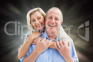 Composite image of happy mature couple embracing smiling at came