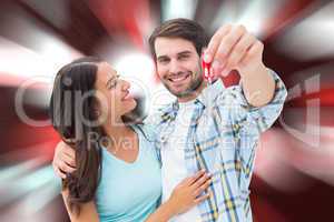 Composite image of happy young couple showing new house key