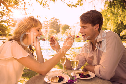 Cute couple feeding each other dessert