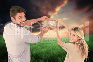 Composite image of attractive young couple hanging a frame