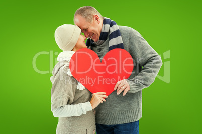 Composite image of happy mature couple in winter clothes holding