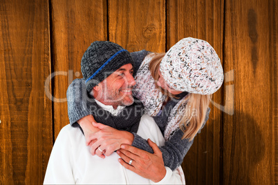 Composite image of happy couple in winter fashion embracing