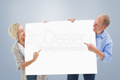 Composite image of mature couple smiling and holding card