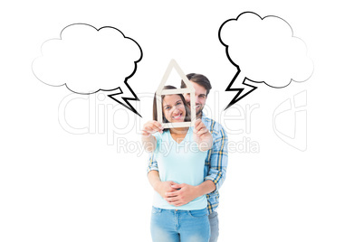 Composite image of happy young couple with house shape