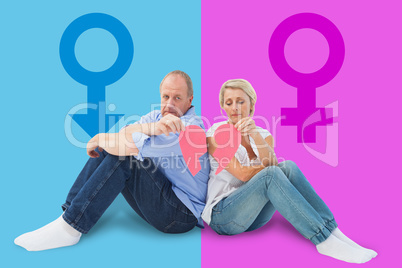 Composite image of sad mature couple holding a broken heart