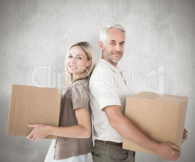 Composite image of happy couple holding moving boxes