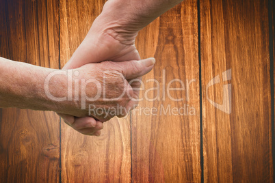 Composite image of elderly couple holding hands