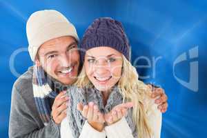 Composite image of attractive couple in winter fashion smiling a