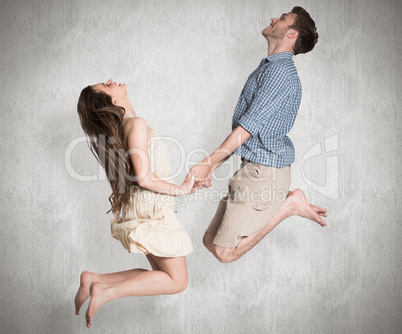 Composite image of cheerful young couple jumping