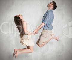 Composite image of cheerful young couple jumping