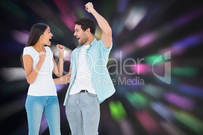 Composite image of happy casual couple cheering together