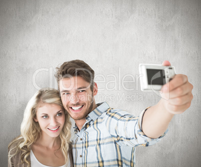 Composite image of attractive couple taking a selfie together Composite image of attractive couple taking a selfie together