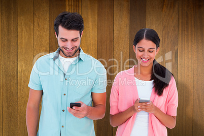 Composite image of happy couple sending text messages