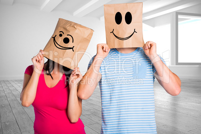 Composite image of young couple with bags over heads