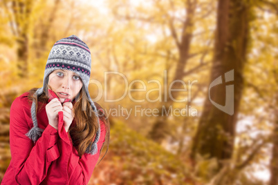 Composite image of cold redhead wearing coat and hat