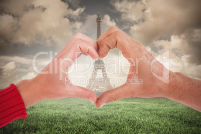 Composite image of couple making heart shape with hands