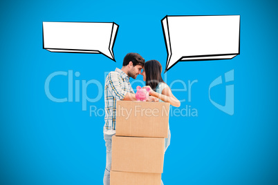 Composite image of happy young couple with moving boxes and pigg