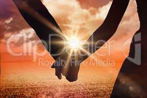 Composite image of mid section of newlywed couple holding hands