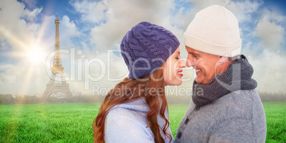 Composite image of couple in warm clothing facing each other Composite image of couple in warm clothing facing each other