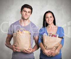 Composite image of young couple holding grocery bags