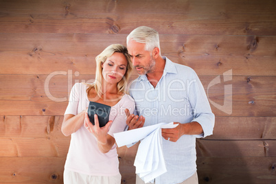Composite image of anxious couple working out their bills