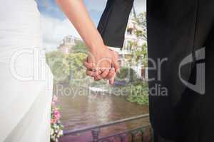 Composite image of close up of cute young newlyweds holding thei