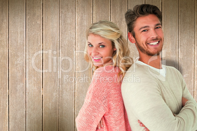 Composite image of attractive couple smiling with arms crossed