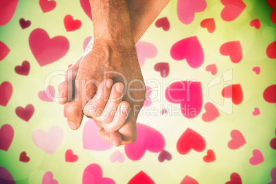 Composite image of happy senior couple holding hands