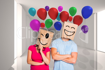 Composite image of young couple with bags over heads