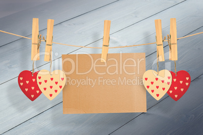 Composite image of hearts hanging on line with card