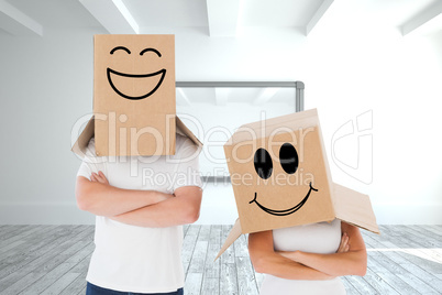 Composite image of mature couple wearing boxes over their heads